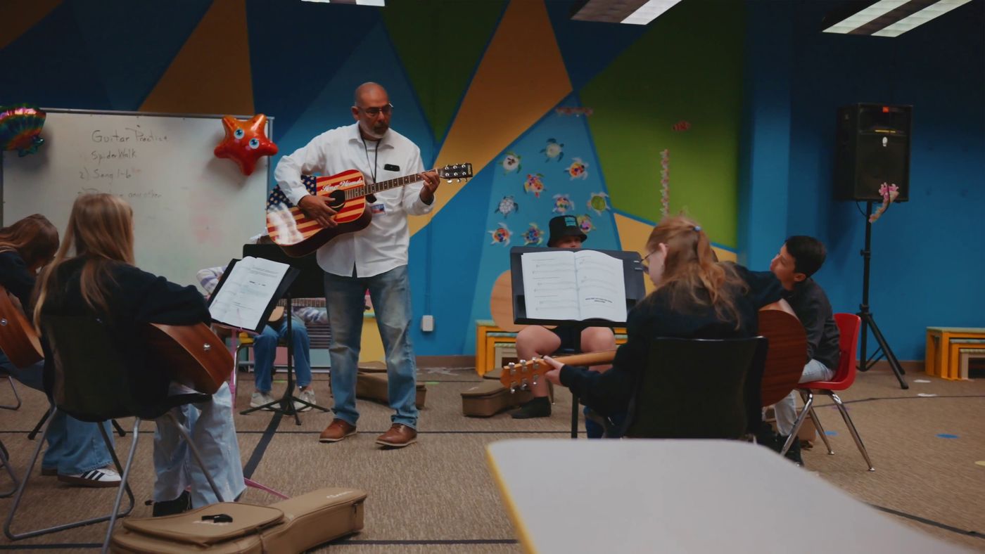 Students in music class playing guitars